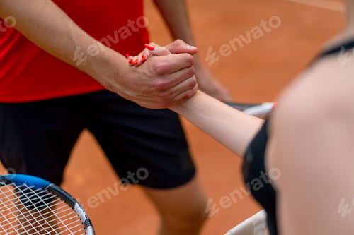 Preview: young man and woman shaking hands before the start of a tennis game on an open court sports