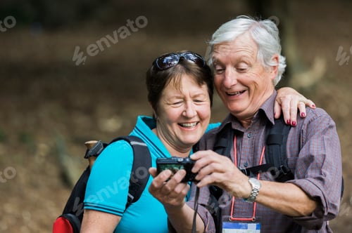 Preview: A mature couple looking at a digital camera, laughing.