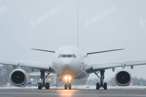 Preview: Passenger plane rides after landing in twilight, winter time. Included landing lights at aircraft
