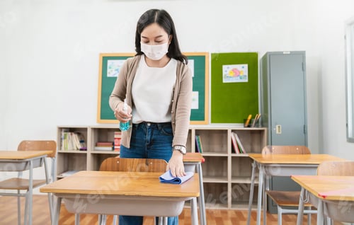 Preview: Young asian teacher cleans up the desk at school foe social distancing