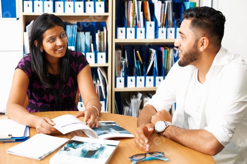 Preview: Female lecturer having tutorial with male student in college classroom