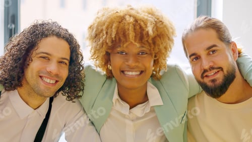 Preview: Colleagues smiling at the camera sitting relaxed on a coworking