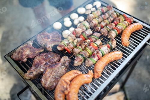 Preview: Selection of meat grilling over the coals on a portable barbecue