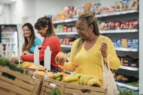 Preview: African senior woman buying fresh organic fruits at supermarket