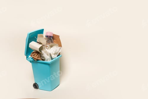 Vista previa: Over full paper trash can on white background with copy space