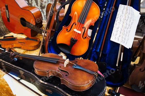 Preview: A display of violins and a guitar in a shop window,