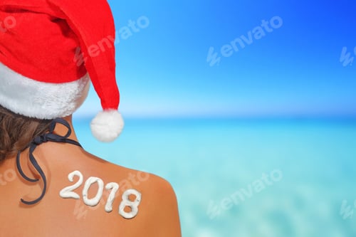 Preview: Summer Christmas Vacation Concept. Woman With Santas Hat And 2018 Written On Her Back, On Blue Sea