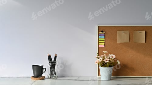 Preview: Workspace sticky note on board, flower and pencil with coffee cup on marble table.