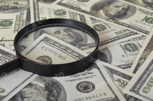 Preview: Magnifying glass and heap of dollars. Financial concept.