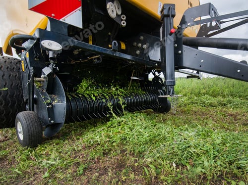 Preview: baler in motion gathers grass on the field creates bales