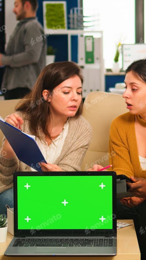 Preview: International business team talking in back of mockup laptop