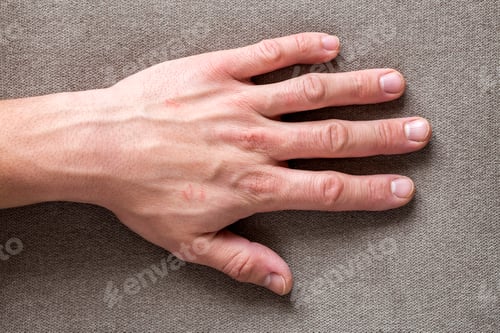 Preview: Close-up of male masculine worker hand with rough skin and short fingernails resting on flat copy