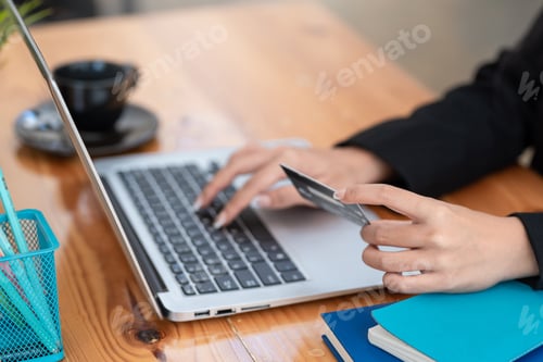 Preview: Business people hold credit cards for shopping online on the laptop at the office.