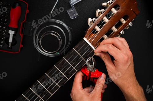 Preview: Guitarist trims excess strings with pliers in classical guitar maintenance. String cutting process