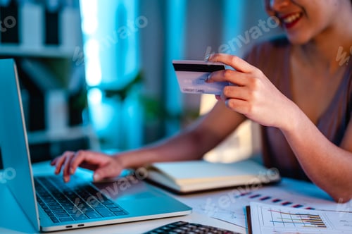 Preview: Close up of asian woman hand working with laptop and credit card at home in to night, paying,payment