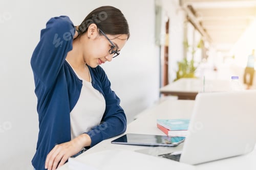 Preview: Asian teen girl neck pain. University woman hard work with laptop and reading book muscle cramp.