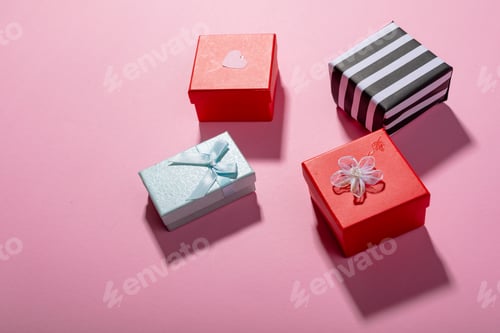 Preview: High angle view of multi colored valentine present boxes on pink background with copy space