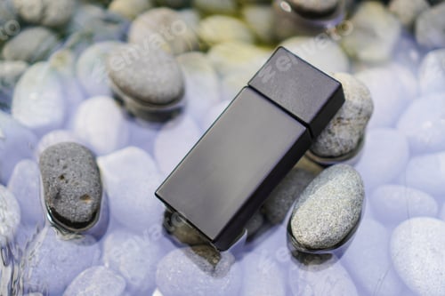 Preview: Black Rectangular Bottle on Pebbles in Water