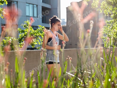 Preview: Young woman listening with earphones