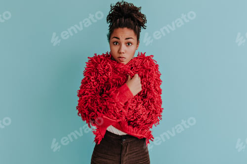 Preview: Surprised young black woman posing in red eco jacket. Front view of beautiful african american girl