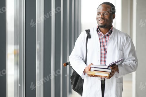 Preview: Man in Lab Coat Holding Books Near Window