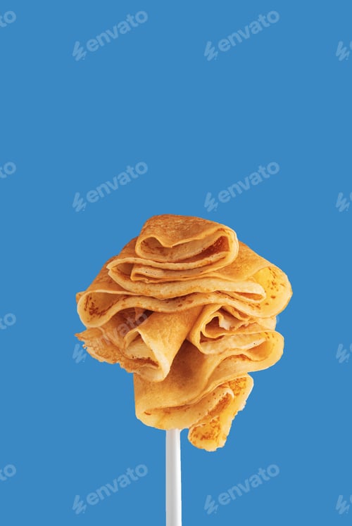 Preview: Golden pancakes on a fork against a vibrant blue background.