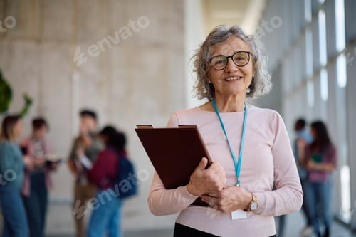 Preview: Happy mature professor at the university looking at camera.
