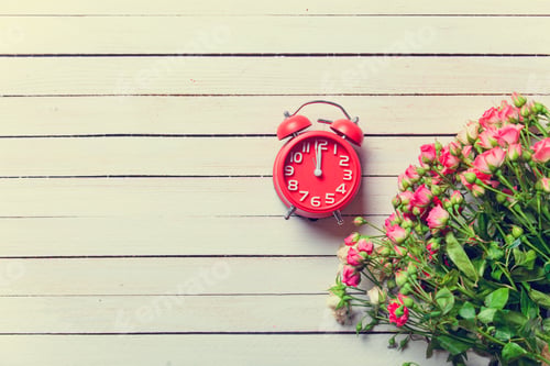 Preview: Beautiful bouquet of roses and retro alarm clock