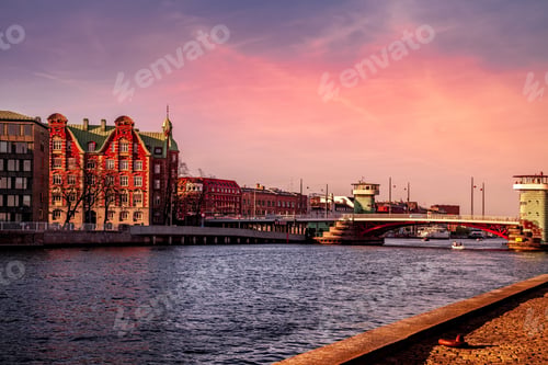 Preview: COPENHAGEN, DENMARK - MAY 6, 2018: scenic view of cityscape with river and bridge in foreground
