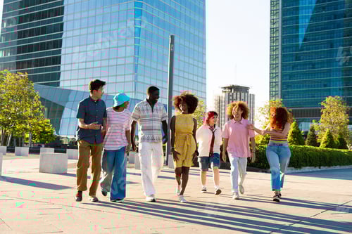 Preview: Multiethnic group of young friends meeting and having fun outdoors