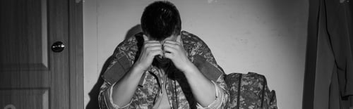 Preview: Black and white photo of frustrated military veteran in uniform sitting in hallway at home, banner