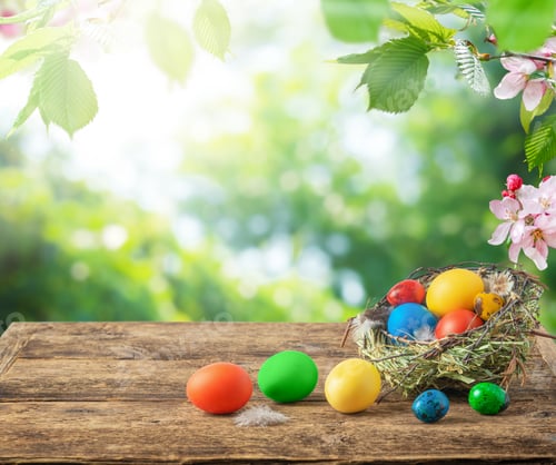 Preview: Colorful Easter eggs on wooden table top on blurred natural bakground. Copy space