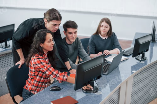 Preview: Look at this. Group of young people in casual clothes working in the modern office