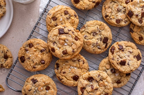 Preview: Chocolate chip cookies on a cooling rack with flaky salt served with milk