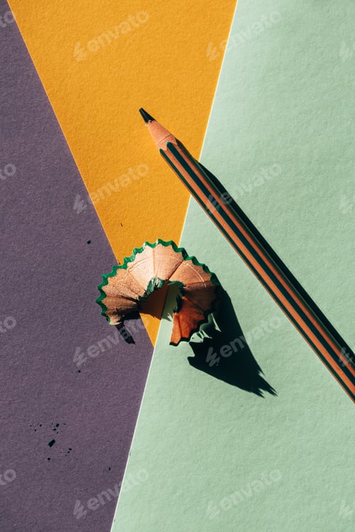 Preview: Pencil and shavings from sharpening, on colored papers backgroun