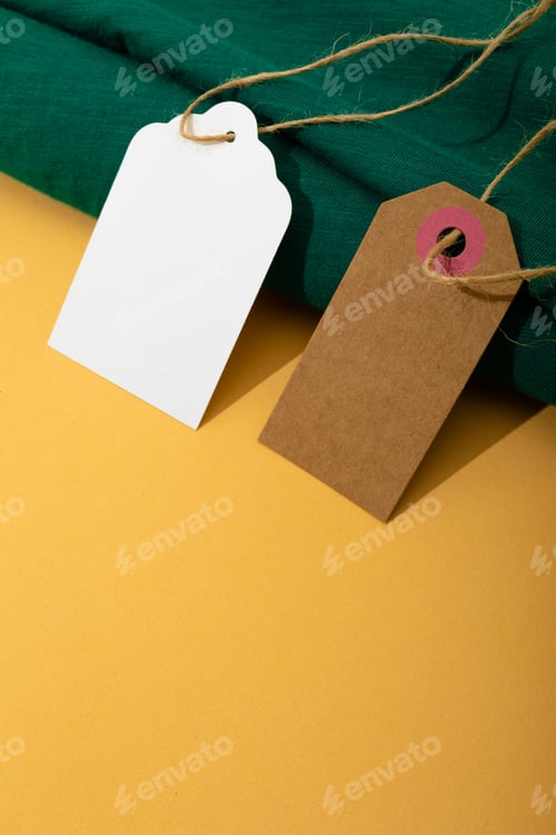 Preview: Composition of gift tags with copy space and green fabric on yellow background