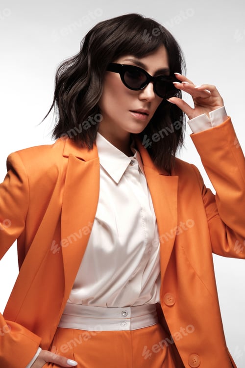 Preview: Spectacular beautiful woman in a trendy orange suit with classic make-up. Beauty face.