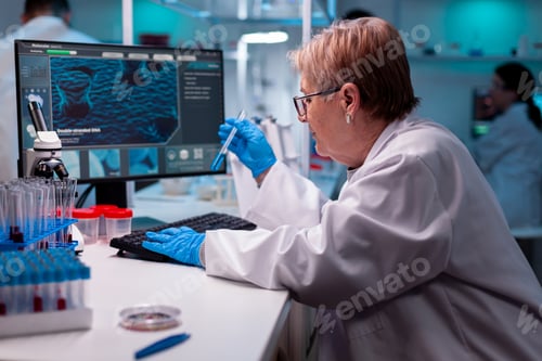 Preview: Scientist typing results of science analysis holding test tube with sample