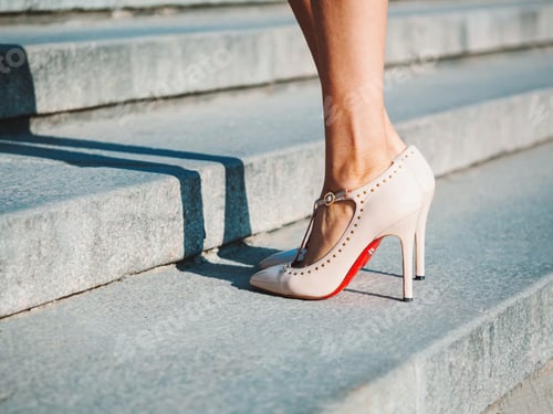 Preview: legs with high beige heels goes down the stairs of big city.Roamntic woman walking on boulvard alone