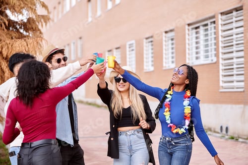 Preview: Group of friends having fun while partying together outdoors.