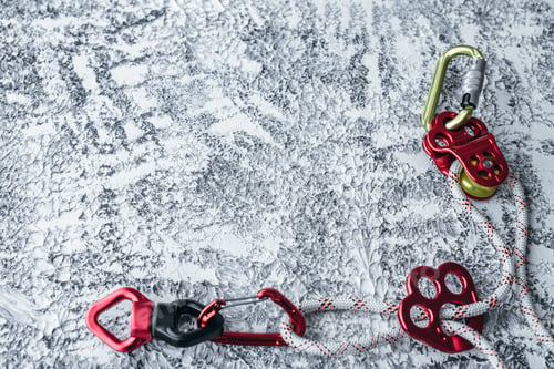 Preview: Isolated photo of climbing equipment. Part of carabiner lying on the white and grey colored table