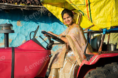Preview: Beautiful Indian bride with tractor in village.