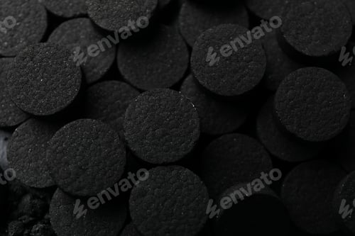 Preview: Pile of black activated charcoal pills close-up