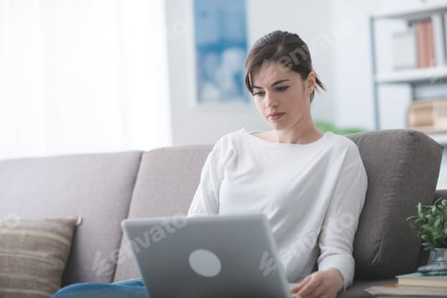 Preview: Woman Relaxing on Sofa Using Laptop Computer