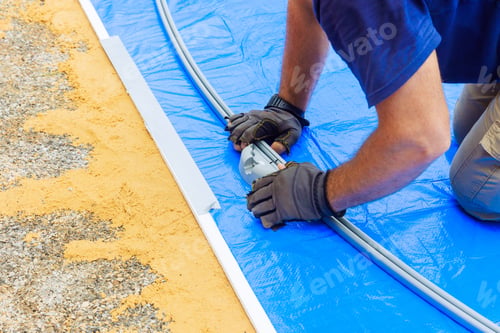 Preview: An above ground pool frame is being assembled by a worker
