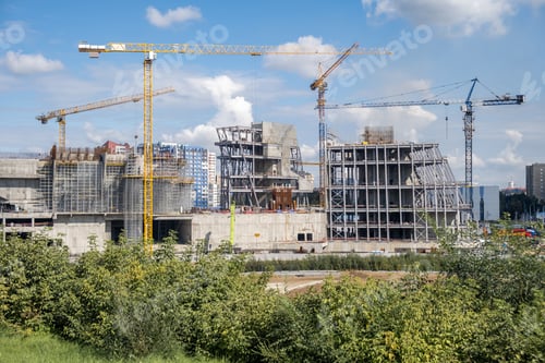 Preview: crane and a building under construction against a blue sky background