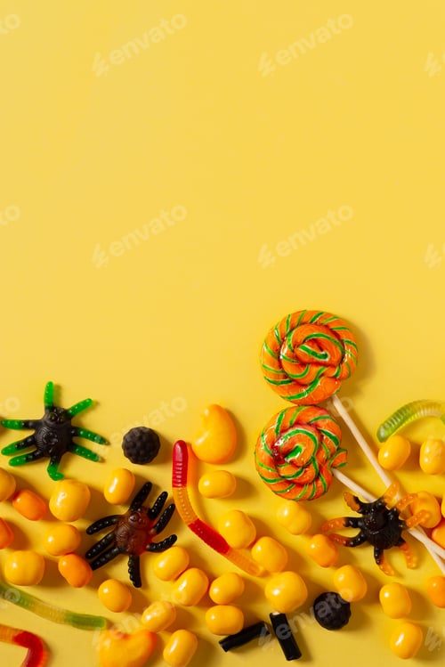 Preview: Sweets candy assorted present for halloween party layout on yellow background, vertical