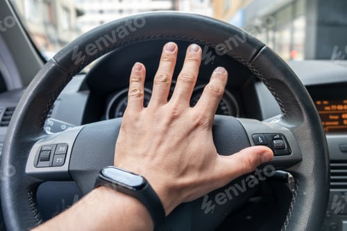 Preview: Drivers hand on a steering wheel of a car.