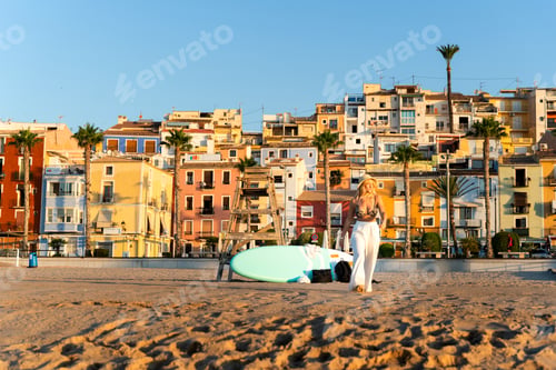 Preview: Tourist walking on the beach at sunrise in villajoyosa, spain