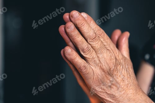 Preview: Hands of an old woman folded for prayer.